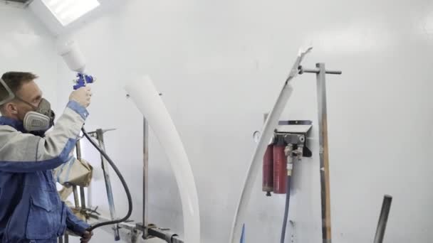 Mužský pracovník maluje kovové detaily v boxu na malování, manuální práci — Stock video