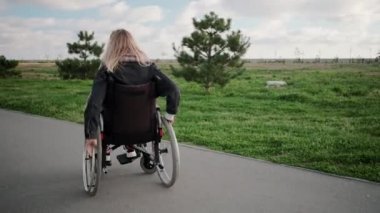 Tekerlekli sandalyede neşeli engelli kadın günün tadını çıkarıyor