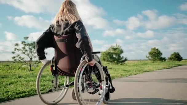 Tranquilla passeggiata solitaria di donna handicappata in sedia a rotelle — Video Stock