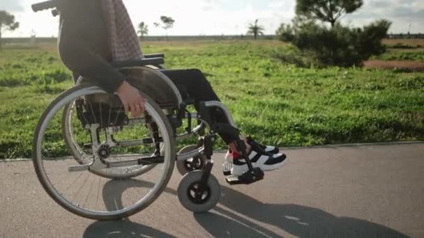 Инвалидная женщина в инвалидной коляске на открытом воздухе — стоковое видео
