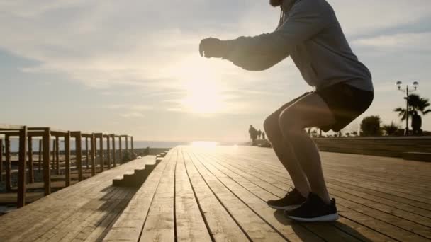 Sportovec je ve slunečném večeru na městském nábřeží, podrobný pohled na tělo — Stock video
