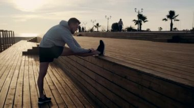 Adam akşam şehir gezinti alanında eğitim, bacak germe