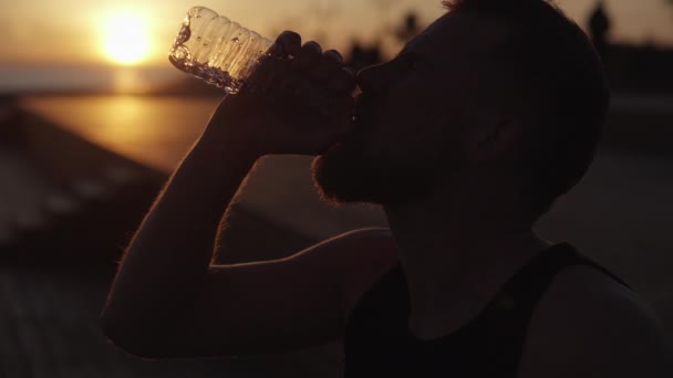 Epische shot van wriemelend gezicht van vermoeide sportman, gieten water op het hoofd, close-up — Stockvideo