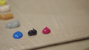 Ressam palet üzerinde tüp dışında boyalar sıkma, yakın çekim