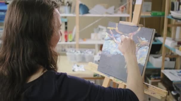 Mulher está pintando quadro por pinturas artísticas a óleo em master class de terapia de arte — Vídeo de Stock