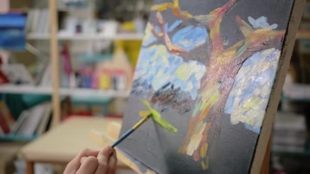 Artista está aplicando gouache amarillo sobre lienzo negro en la escuela de arte, de cerca — Vídeo de stock