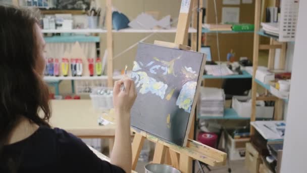 Vrouw kunstenaar is het maken van lijnen door verven in workshop, het tekenen van een foto — Stockvideo