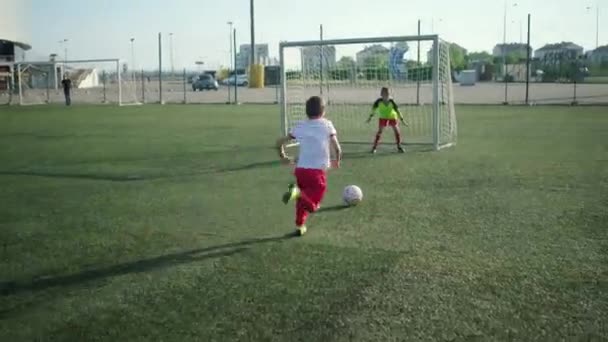 Unga skolpojke fotbollsspelare motstår vän attack — Stockvideo