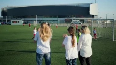 Kadın taraftarlar küçük erkek futbol takımının eğitim izliyor