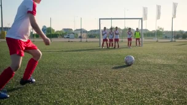 Jovem jogador de futebol faz chute livre no portão — Vídeo de Stock