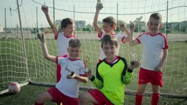 Ganar el equipo de fútbol de los niños pequeños está demostrando recompensas en el estadio — Vídeo de stock