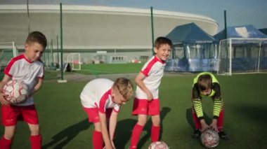 genç çocuklar okul çocukları futbol sahasında topları koymak