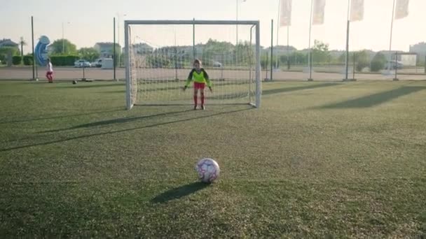 Молодий хлопчик воротар у футбольній формі пропускає постріл — стокове відео