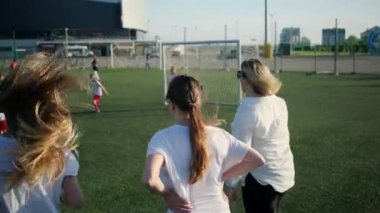 kadınlar futbol sahasında çocuk futbol oynamak izlemek