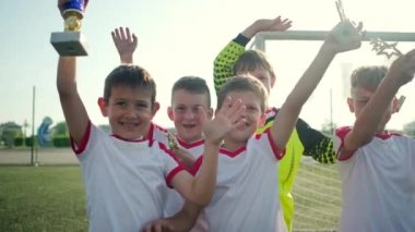 futbolcular kapı tarafından kupa tutan el sallamak