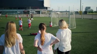 Kadınlar eğitim küçük futbolcuların oyun tartışıyor