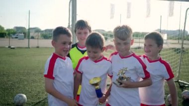 genç gülümseyen schoolboys kupa ve sarılmak tutun