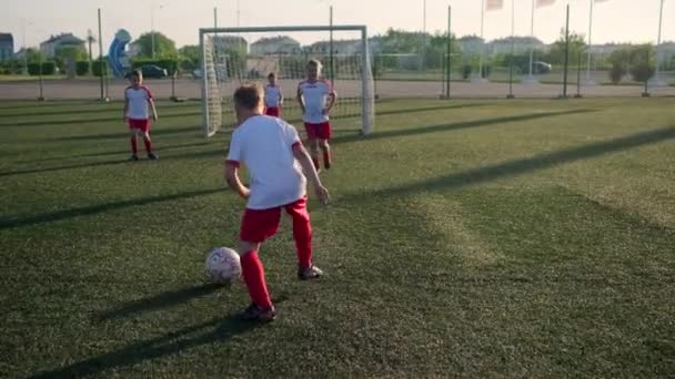 Boy futebolista é driblando bola e chutando gol — Vídeo de Stock