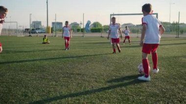 Küçük futbolcular dan oluşan bir grup futbol oynuyor, gol atıyor