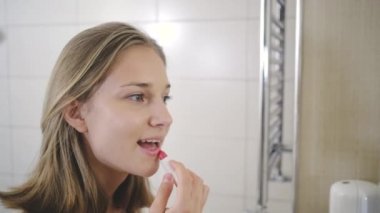 sarışın kız banyoda kırmızı ruj koyar