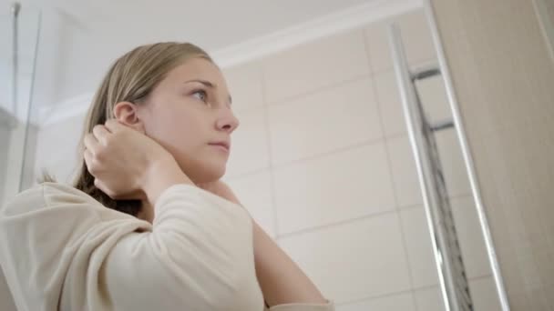 Blond dziewczyna naprawia włosy za uszy i sprawdza makijaż — Wideo stockowe