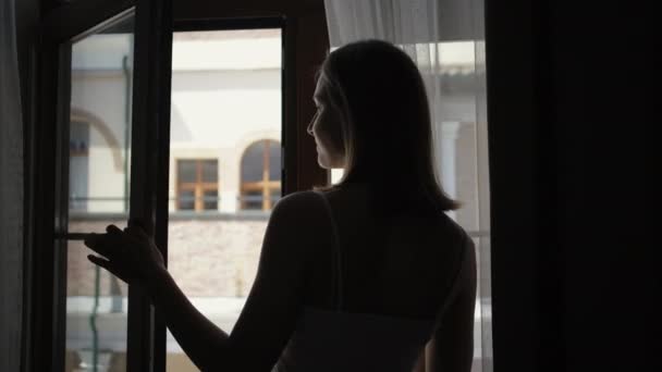 Girl Silhouette öppnar fönster mot grannhus — Stockvideo