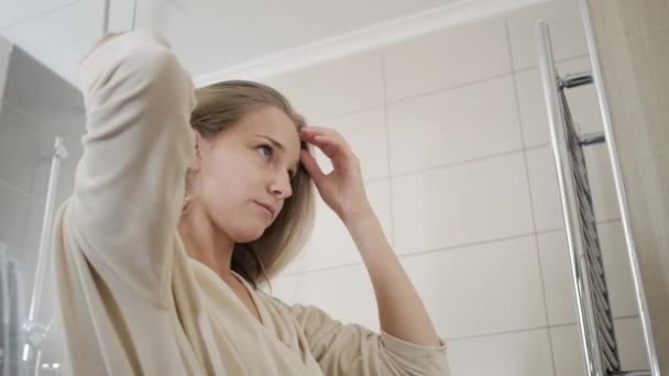 Genç kadın banyoda fırça ile saç tarar — Stok video