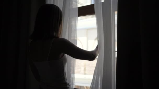 Mujer moviendo cortinas y ventana de apertura, mirando a la calle — Vídeo de stock