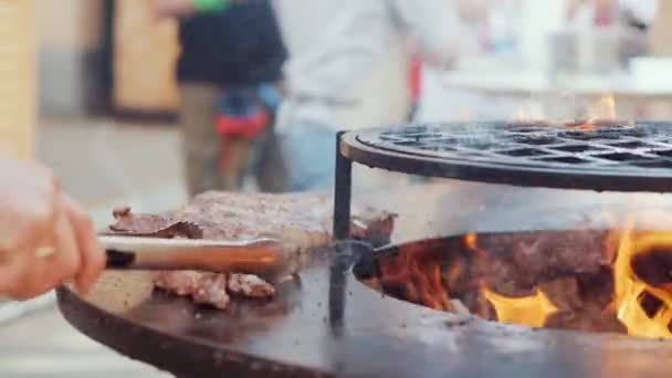 Cocinero prepara rebanadas de carne con pinzas y espátula — Vídeos de Stock