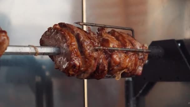 Spareribs roasting on metal spit during food fest — Stock Video