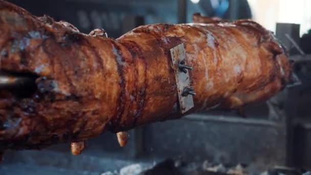 Roasted lamb is rotating on spit of grill — Stock Video