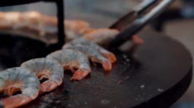 Şef ızgara sıcak tabaküzerinde karides dönüyor