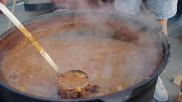 Koch rührt Suppengulasch in großem Topf — Stockvideo