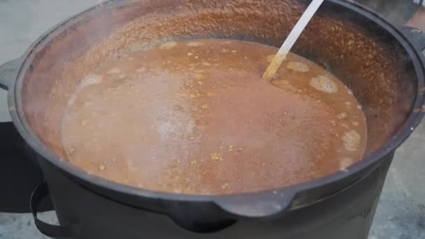 Koch gießt Salz in Suppe in Schüssel — Stockvideo