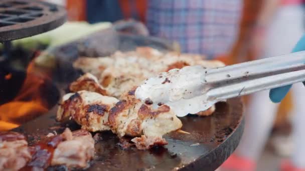 Cook er ved at vende anden slags kød på stegepladen – Stock-video