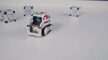 Robotik oyuncak araba masada hareket ediyor, insan eli onu deviriyor