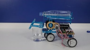 Robotik makine cam şişeden su döküyor