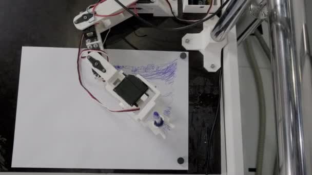 Programmable robotic arm draws with pen on paper sheet — Stock Video