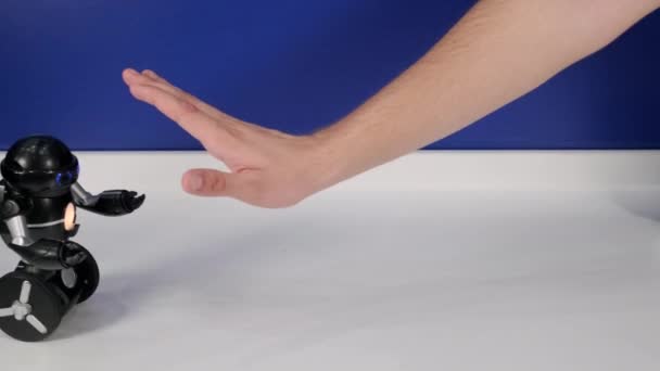 Robot rolling on wheels directed by movements of human hand — Stock Video