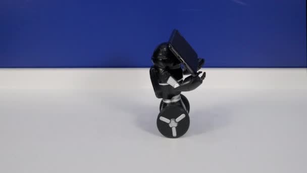 Robot roule sur roues et tenant smartphone par les mains 