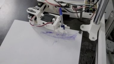 Robotik cihaz kalem ve çizim tutuyor