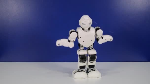Pequeño robot hace movimientos de baile y sentadillas en el stand — Vídeos de Stock
