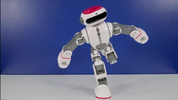 Small robotic humanoid stands on leg at exhibition — Stock Video