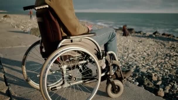 Handicapped man in wheelchair is alone with sea — Stock Video