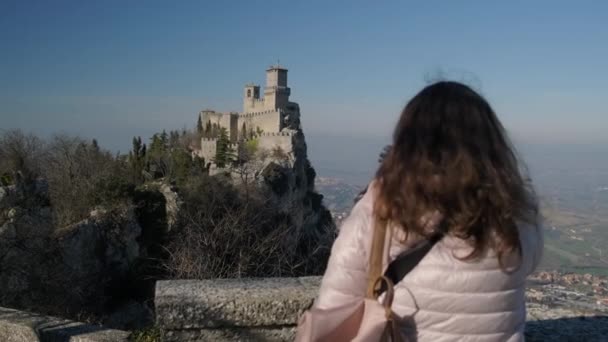 Tourist mit Tasche blickt auf Festung des Guaita-Turms — Stockvideo