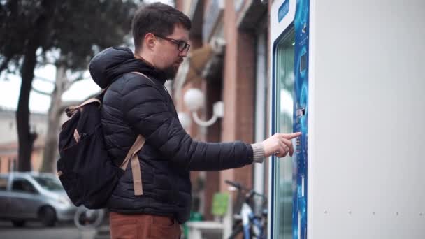 Városi ember gombokat nyomogat az utcai automatán. — Stock videók