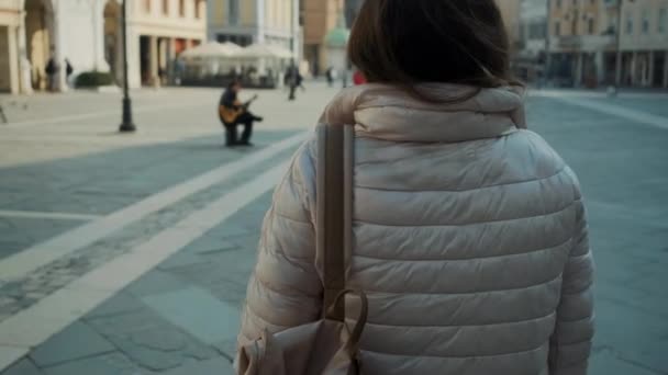 Donkerharige dame loopt langs groot plein — Stockvideo