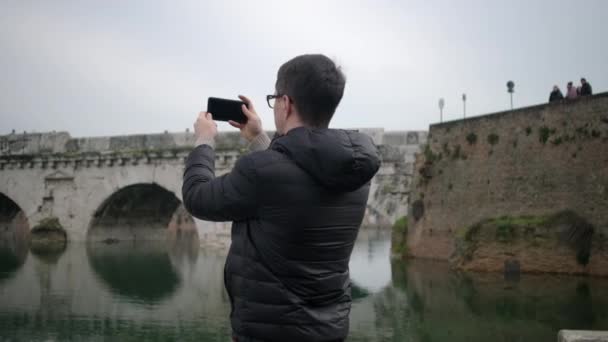 Mens films oude atchitecture reflecteren in de rivier — Stockvideo