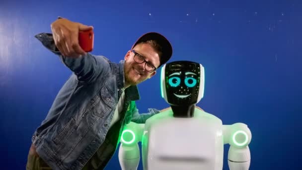 Emocjonalny robot pozujący do selfie wesołego mężczyzny — Wideo stockowe