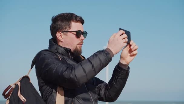 Турист у сонцезахисних фільмах атракціони на смартфоні — стокове відео